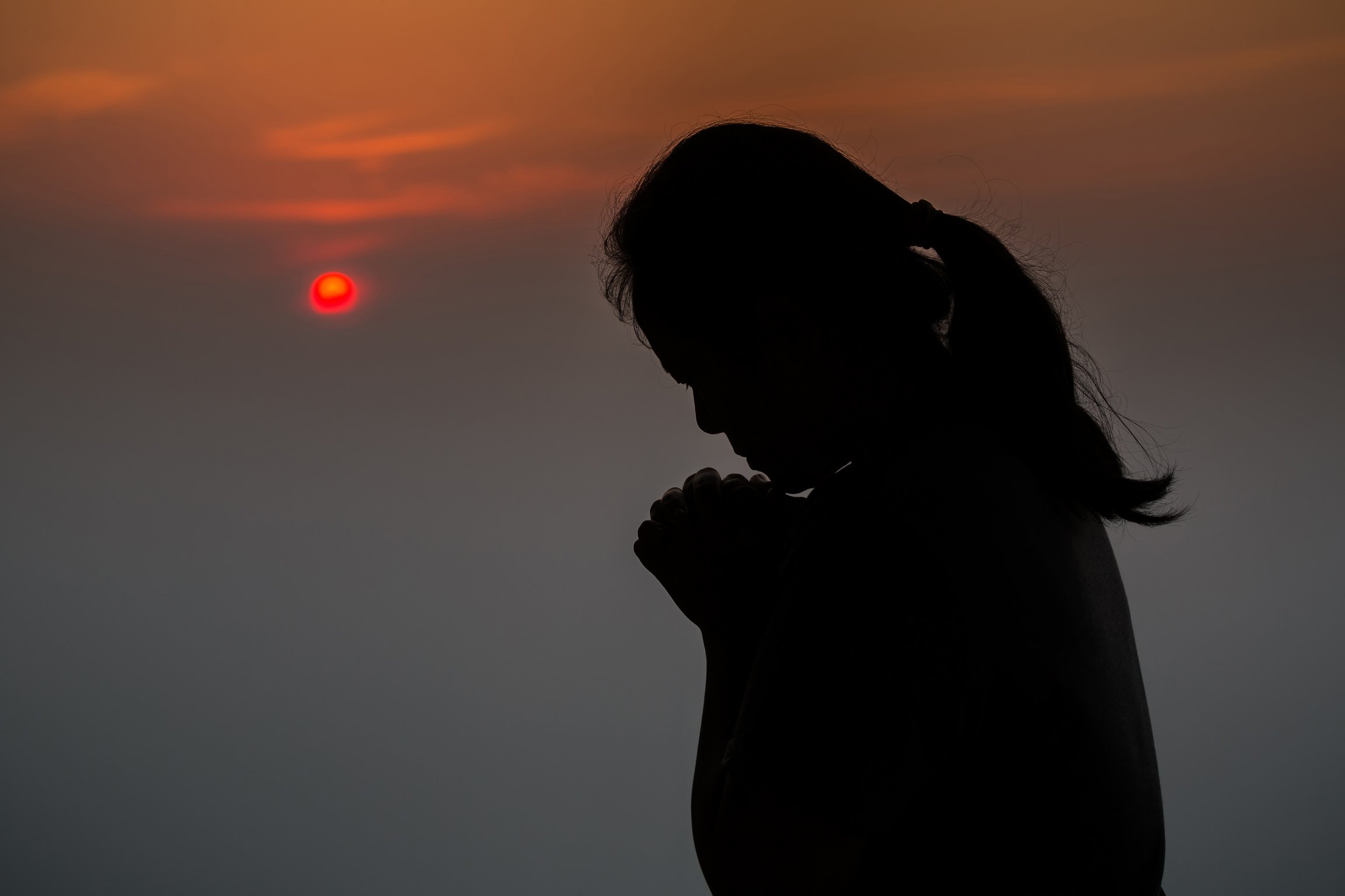 Silhouette of Woman Praying in the Morning